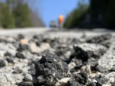 a pothole with a high-vis worker in the background