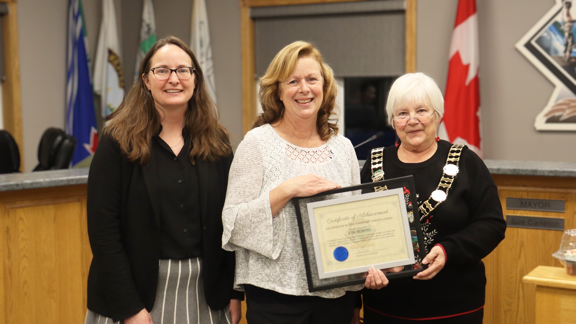 Council members presenting a volunteer certificate