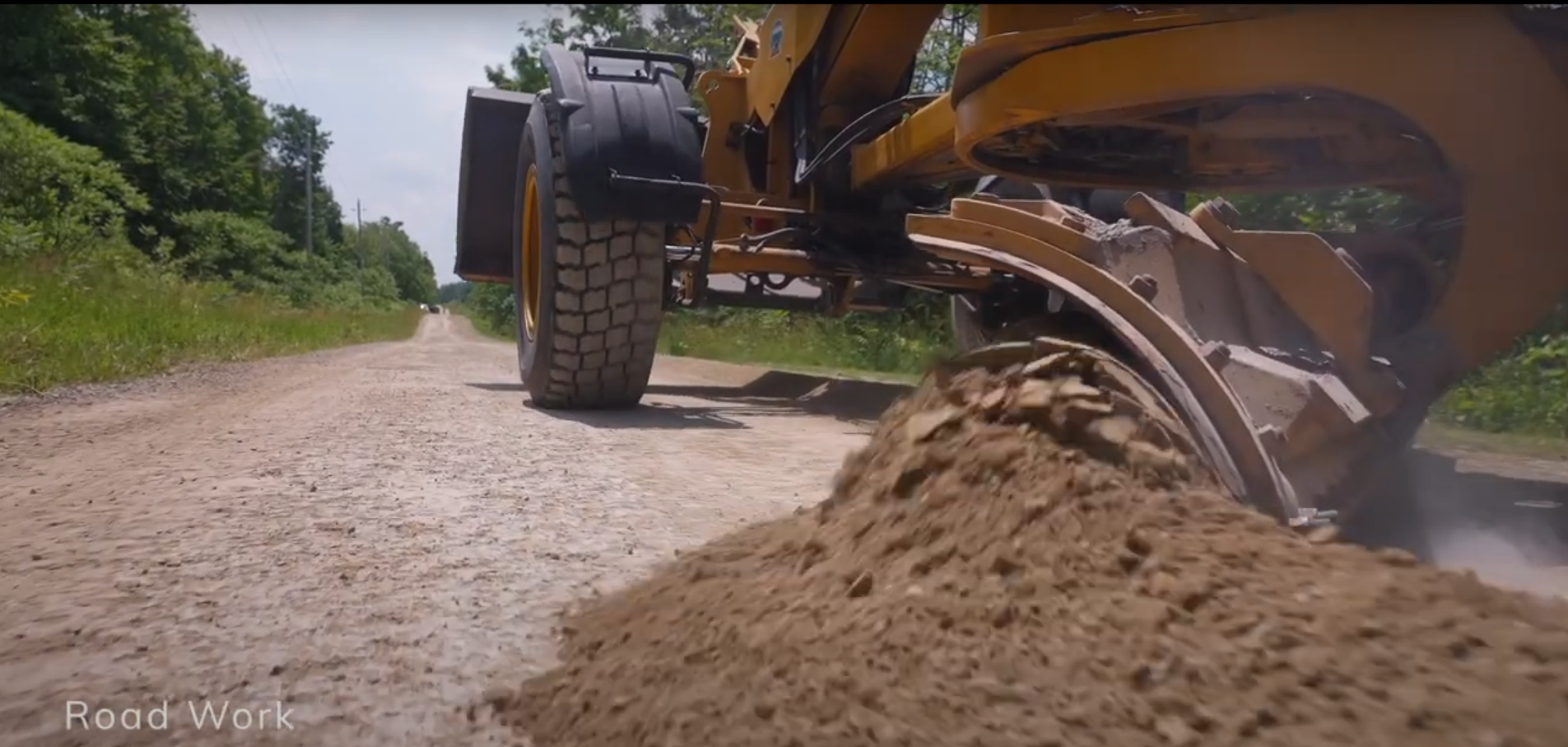 A grader on a gravel road.
