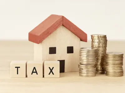 a small wooden house and wood blocks spelling out "tax"