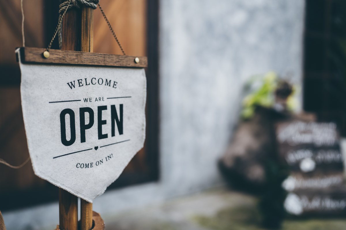 a cafe door sign that says welcome - we are open.