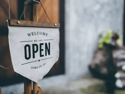 a cafe door sign that says welcome - we are open.
