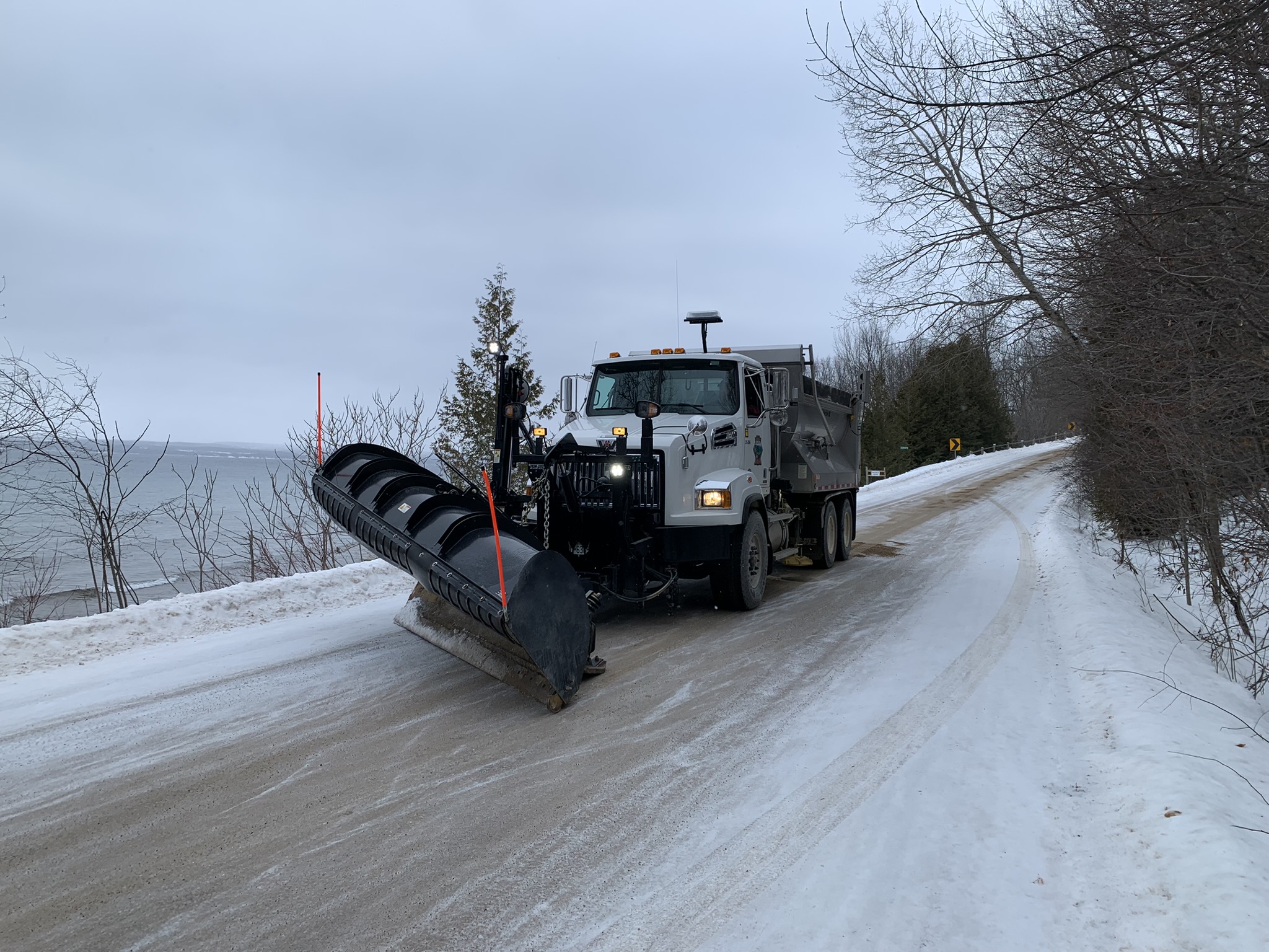 A plow on a winter gravel road along Georgian Bay.